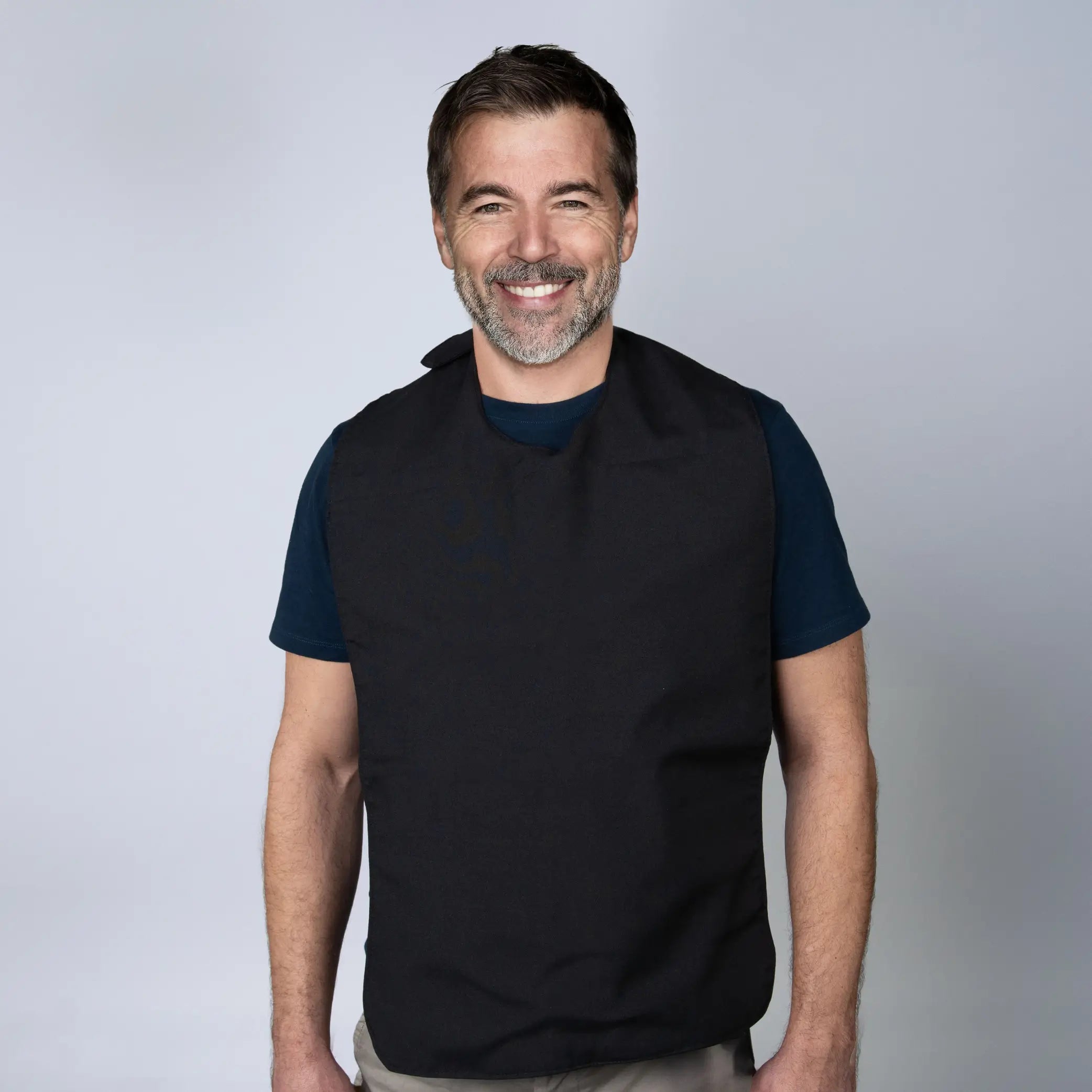 Man wearing a black StayDry absorbent and waterproof clothing protector bib. Designed for adults and seniors, this full-coverage bib offers protection against spills, stains, and moisture