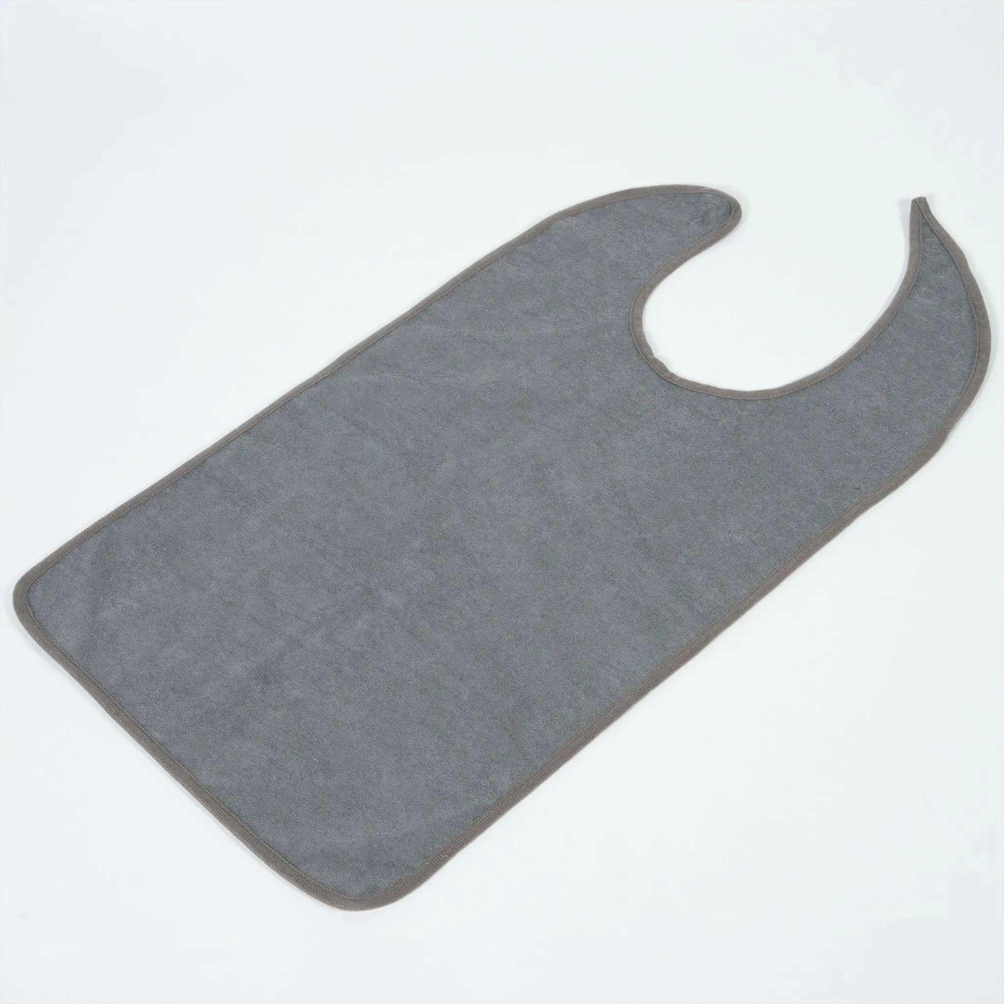 StayDry absorbent and waterproof clothing protector in grey, laid flat to showcase its full coverage design. This adult bib features a soft, absorbent front layer and a waterproof backing, ideal for protecting clothing from food spills and liquids during meals.