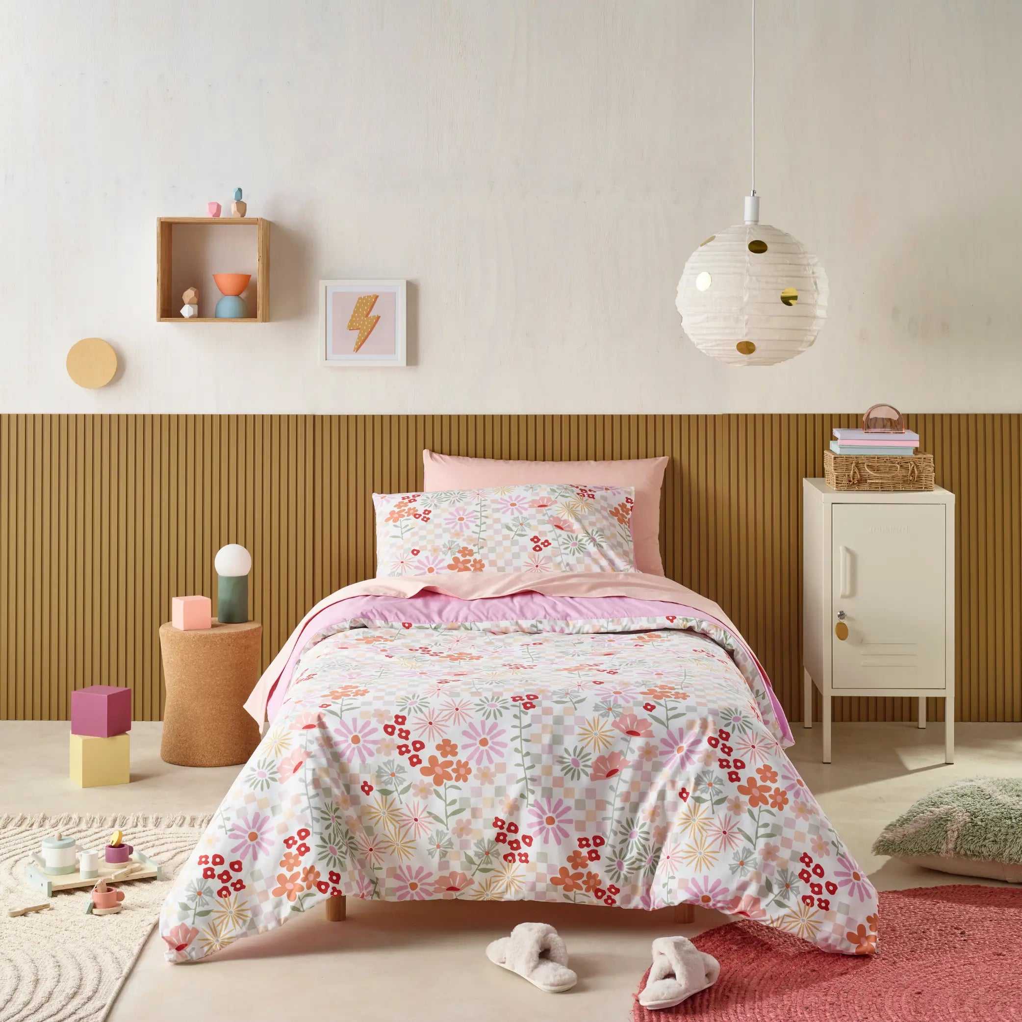 Kids' bedroom featuring a vibrant, water-resistant floral quilt cover set with a mix of pastel and bright red flowers.