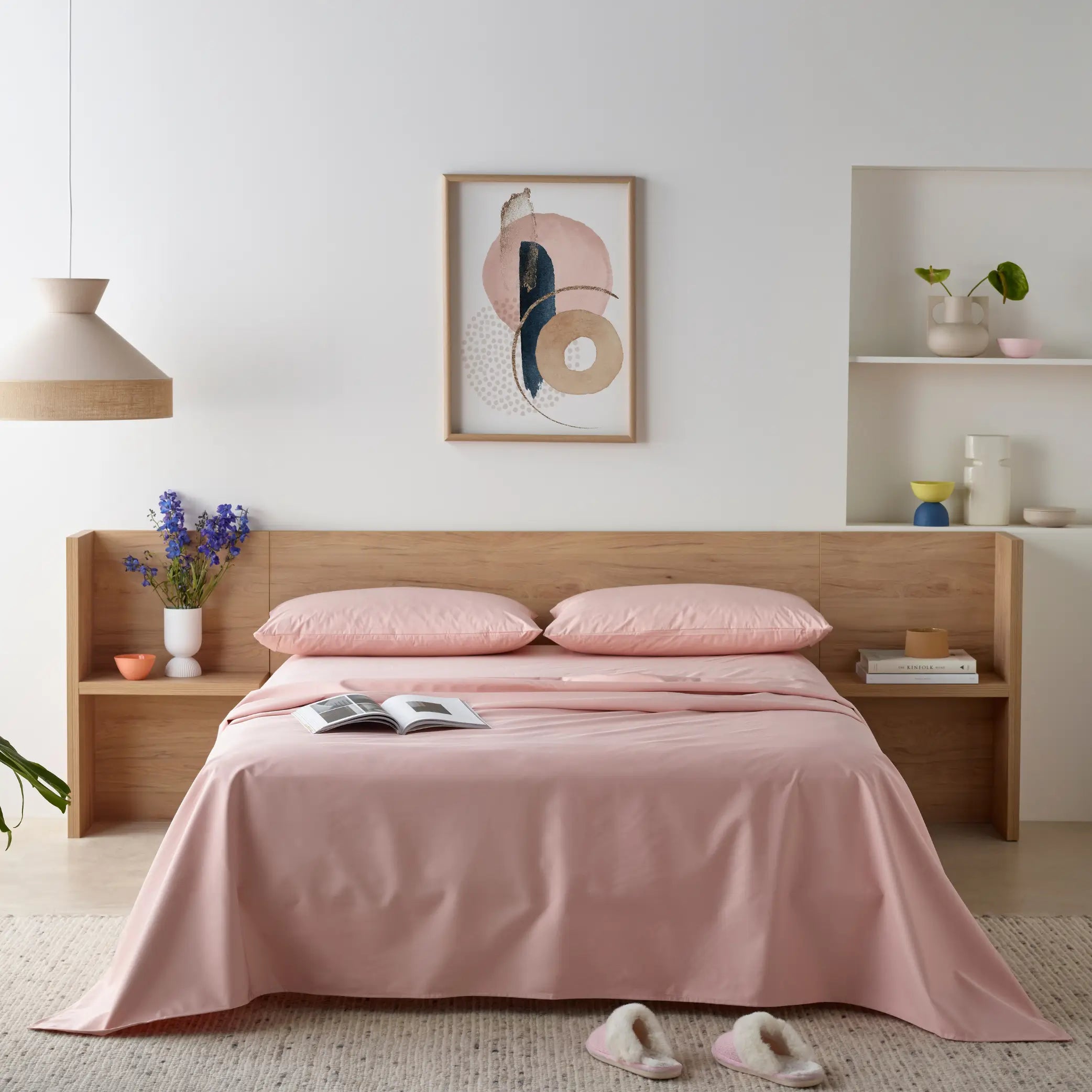 Blush pink waterproof bamboo fitted sheet on a modern wooden bed frame. This luxurious, hypoallergenic, and liquid-resistant sheet offers breathable comfort, deep-pocket fit, and ultimate protection for a fresh and dry sleep.