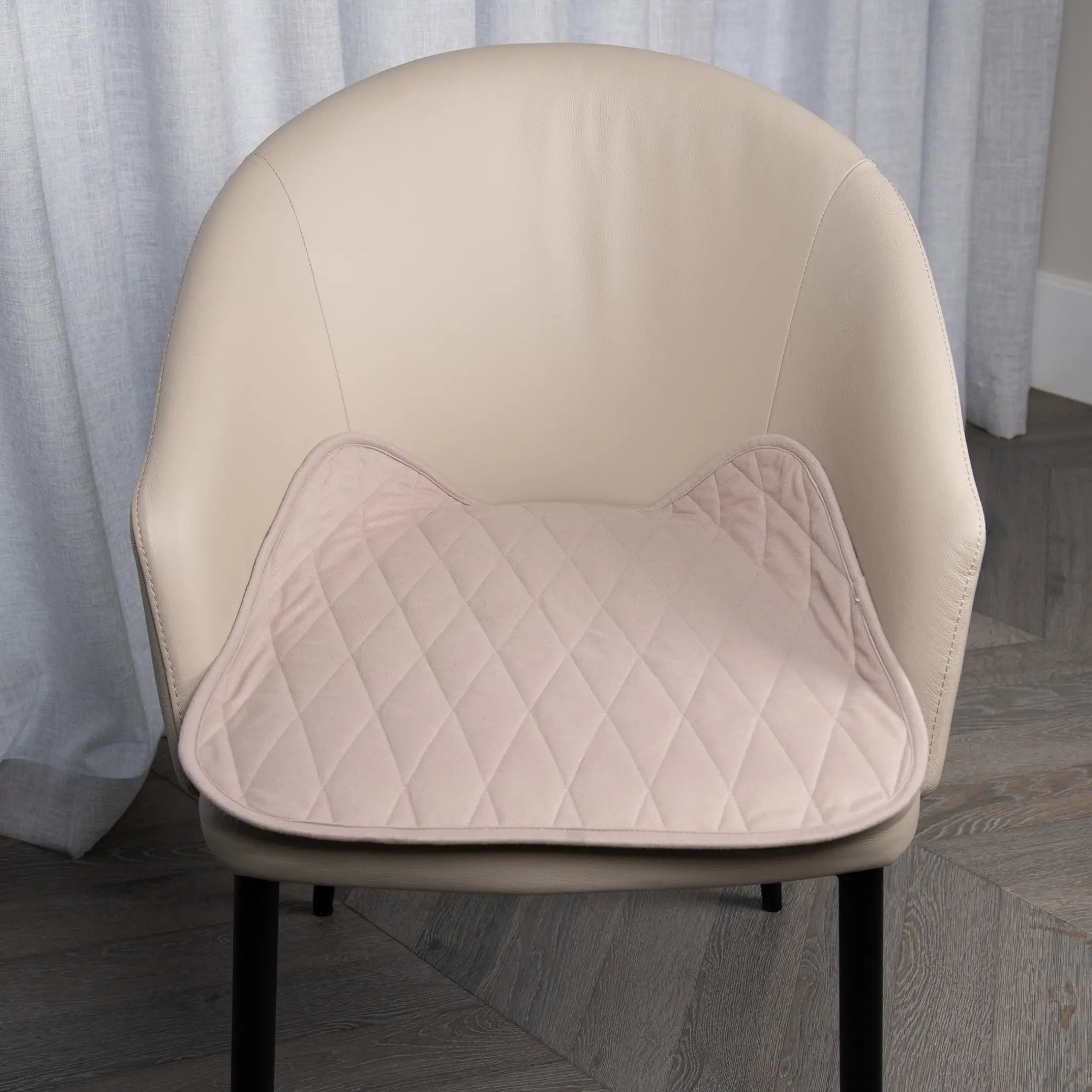 Bone-coloured waterproof chair pad with a quilted design placed on a beige upholstered chair, offering protection from spills, leaks, and everyday wear. Ideal for dining chairs, office chairs, wheelchairs, and incontinence support.