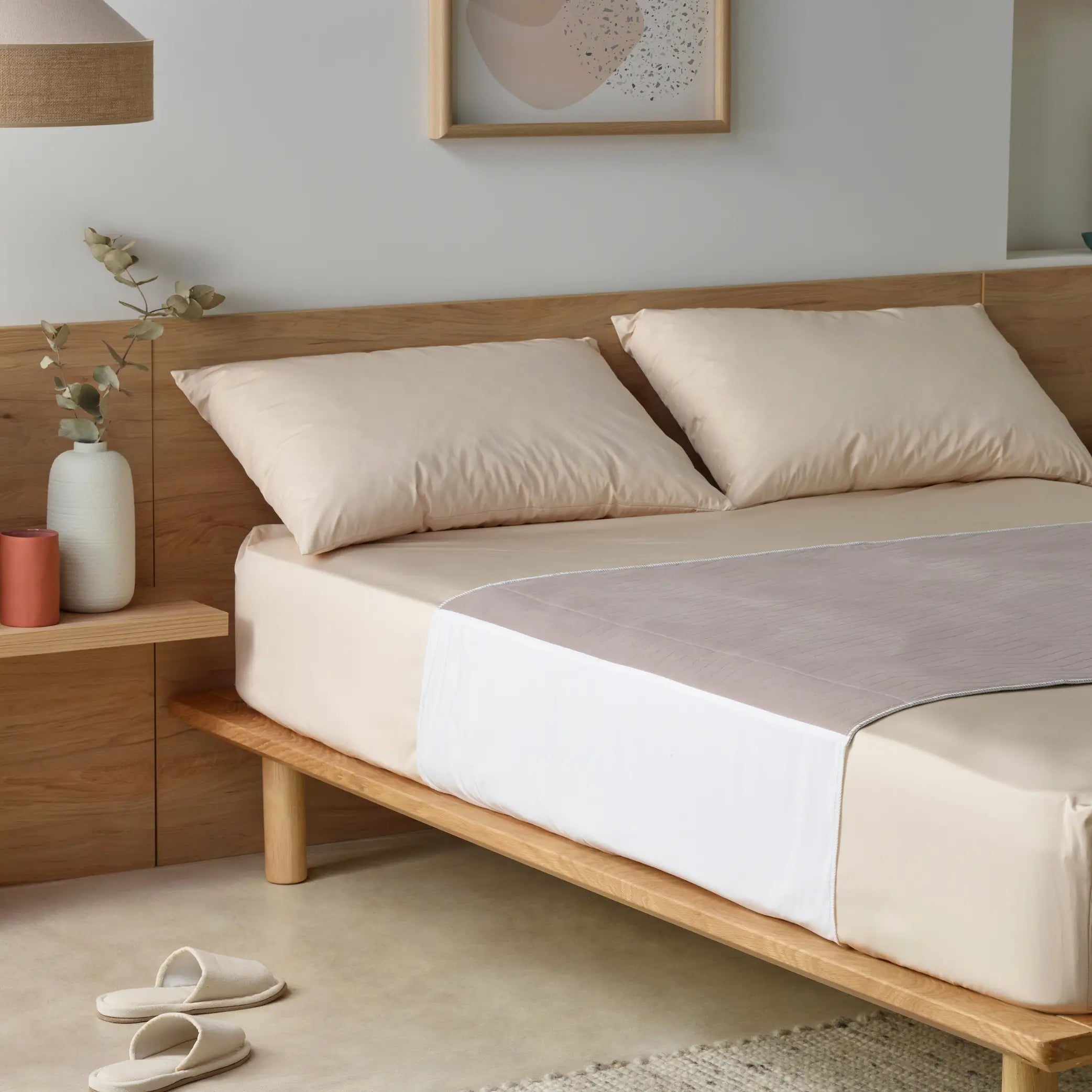 Clay-coloured waterproof bed pad placed on a stylish neutral-toned bed. This reusable incontinence bed pad offers high absorbency, leak-proof protection, and a soft quilted design for maximum comfort. Ideal for protecting mattresses from spills, accidents, and night-time incontinence.