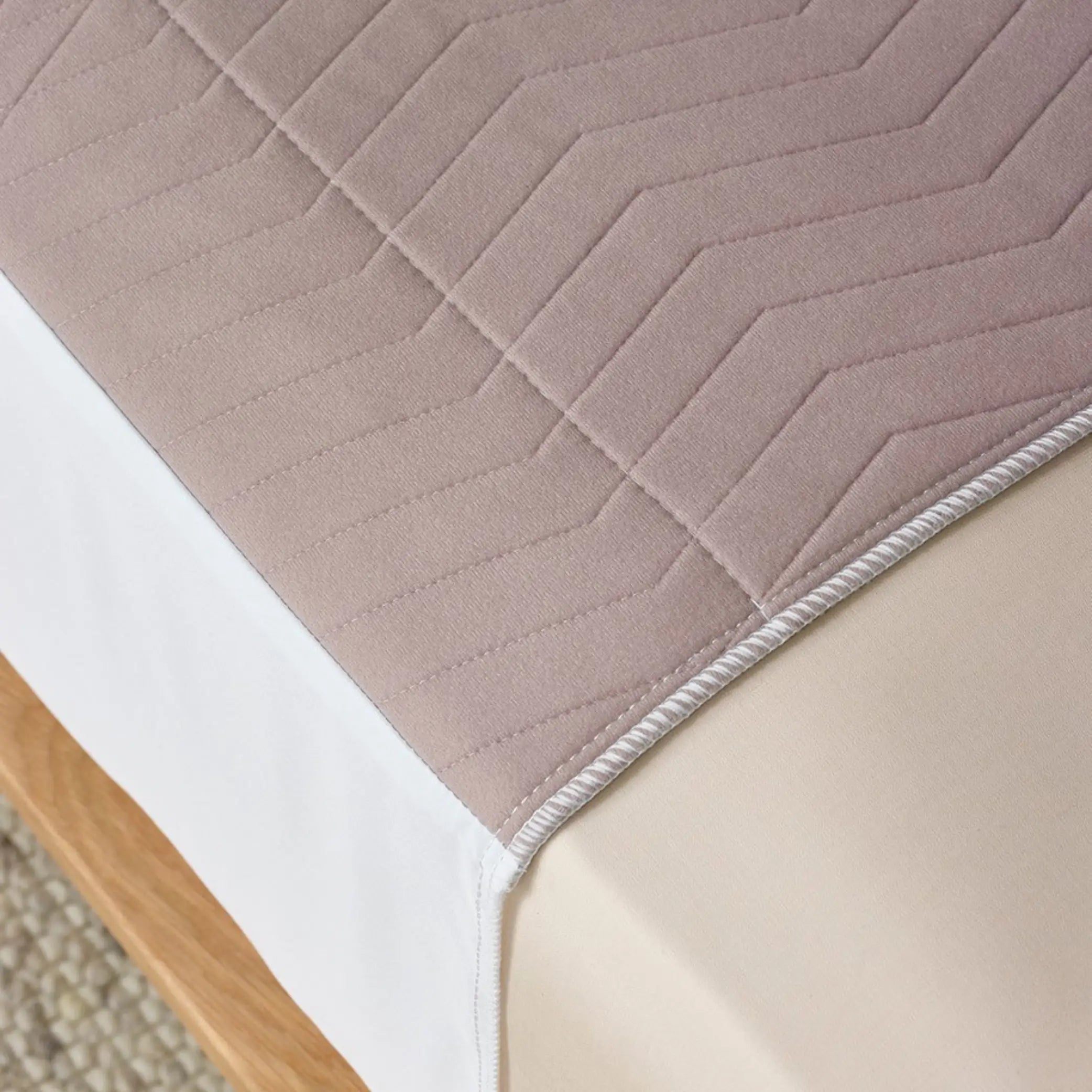 Close-up of the Clay Waterproof Bed Pad in warm neutral tones, featuring a soft, quilted design for extra comfort. This reusable and washable bed pad provides incontinence protection with high absorbency and a waterproof backing to keep mattresses dry.