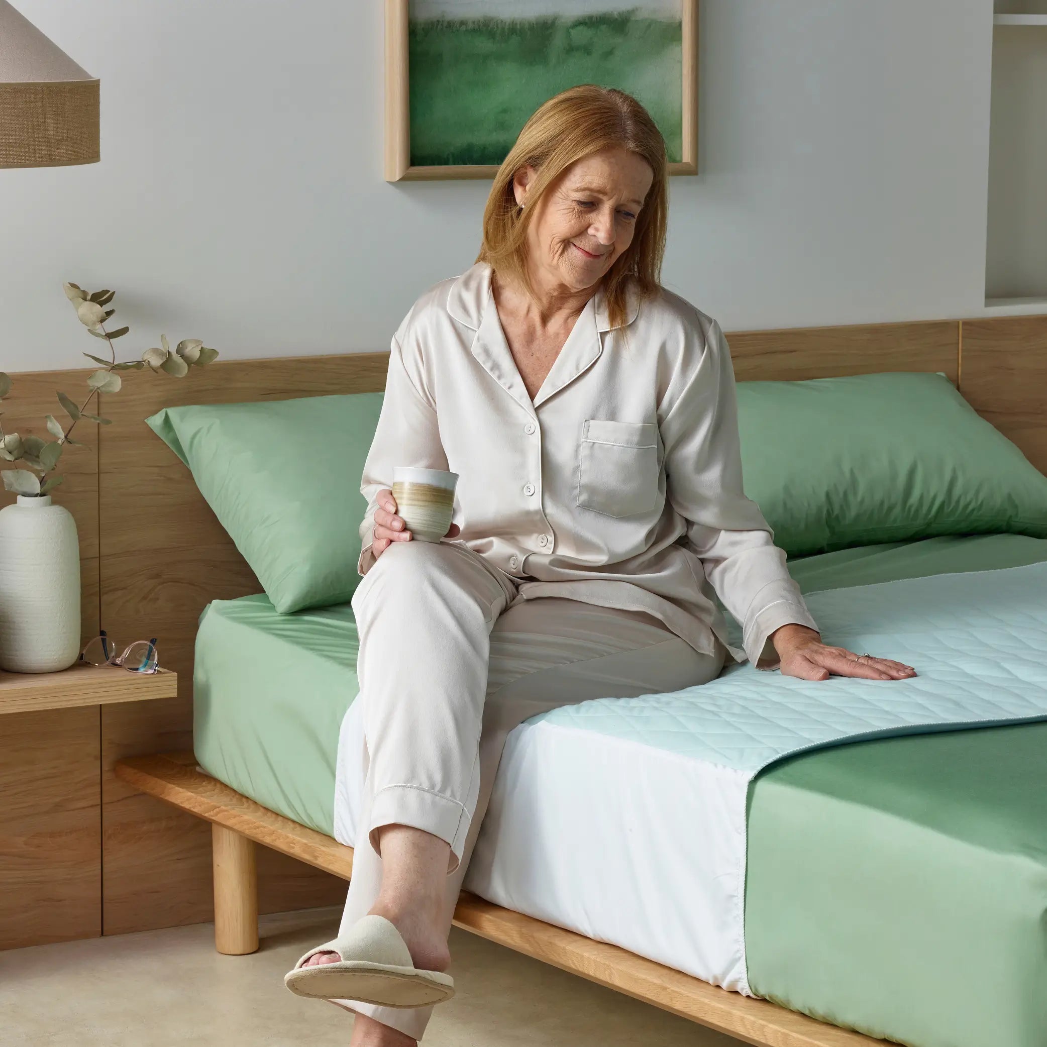 Senior woman enjoying a comfortable rest on a lightweight blue waterproof bed pad. This absorbent incontinence bed pad provides soft, breathable, and leak-proof protection for better sleep quality.