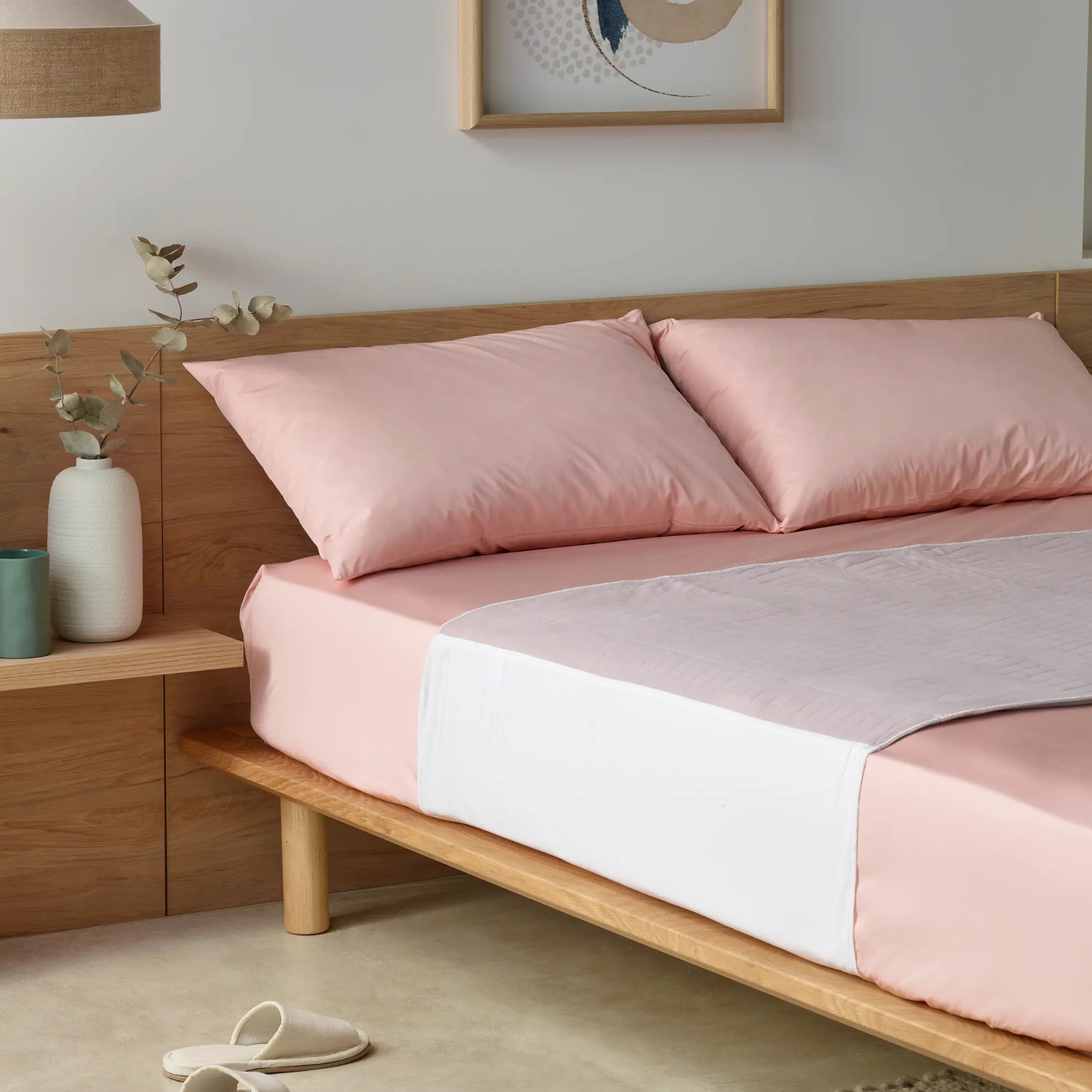 Lilac waterproof bed pad elegantly placed on a soft pink bed set. This high-absorbency, reusable incontinence pad provides leak-proof protection while ensuring a comfortable and stylish sleep environment. Ideal for night-time accidents, spills, and mattress protection.