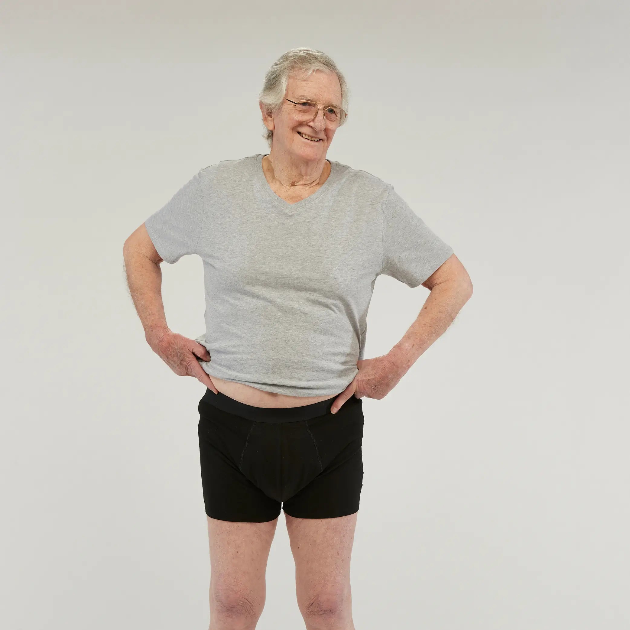 Elderly man wearing StayDry men's waterproof incontinence boxer briefs in black. Designed for leak-proof protection.