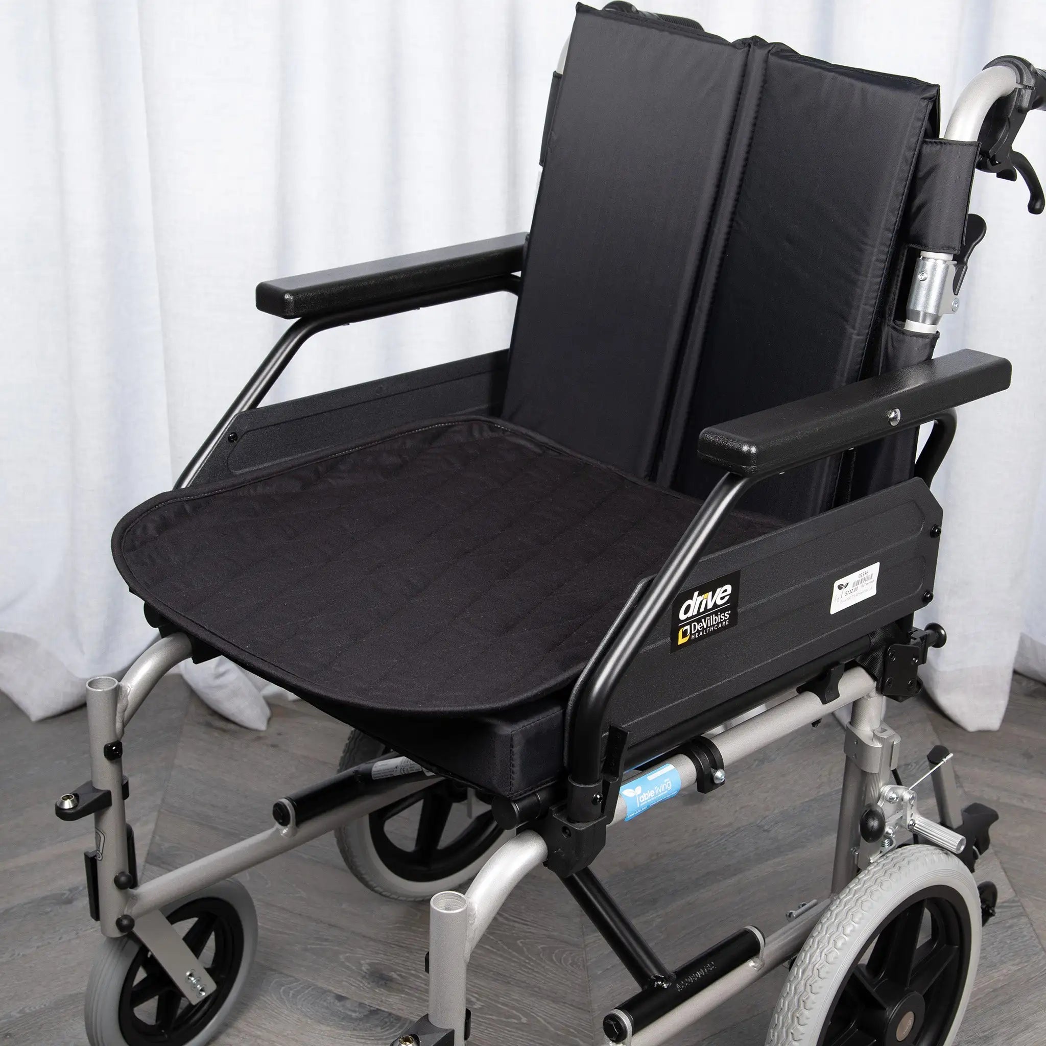 Black waterproof wheelchair pad with a quilted design, providing protection against spills, leaks, and incontinence. Designed for enhanced comfort and security, fits standard wheelchairs for daily use and mobility support.