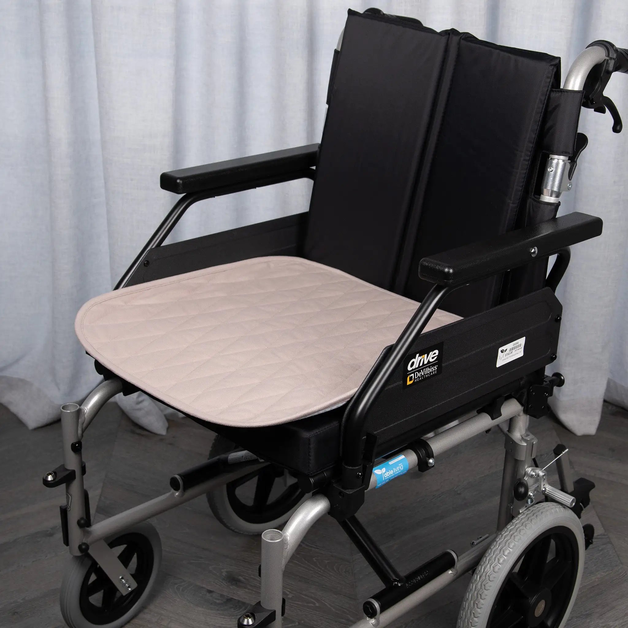 Bone-coloured waterproof wheelchair pad with a quilted, absorbent design for incontinence protection. Offers comfort, mobility support, and spill-resistant coverage, fitting standard wheelchair seats securely.