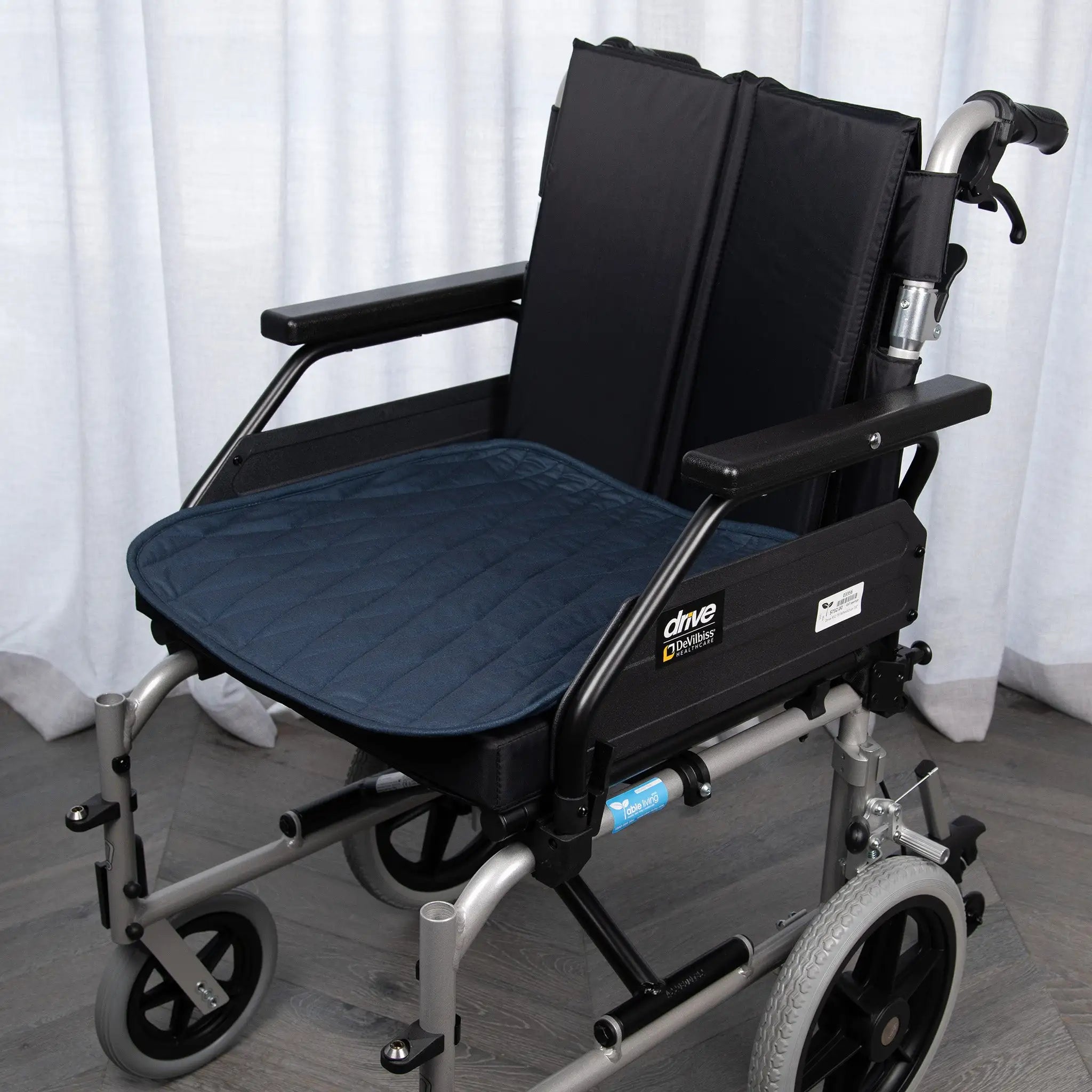 Midnight blue waterproof wheelchair pad with a quilted, absorbent design for incontinence protection. Provides comfort, mobility support, and spill-resistant coverage, fitting standard wheelchair seats securely.