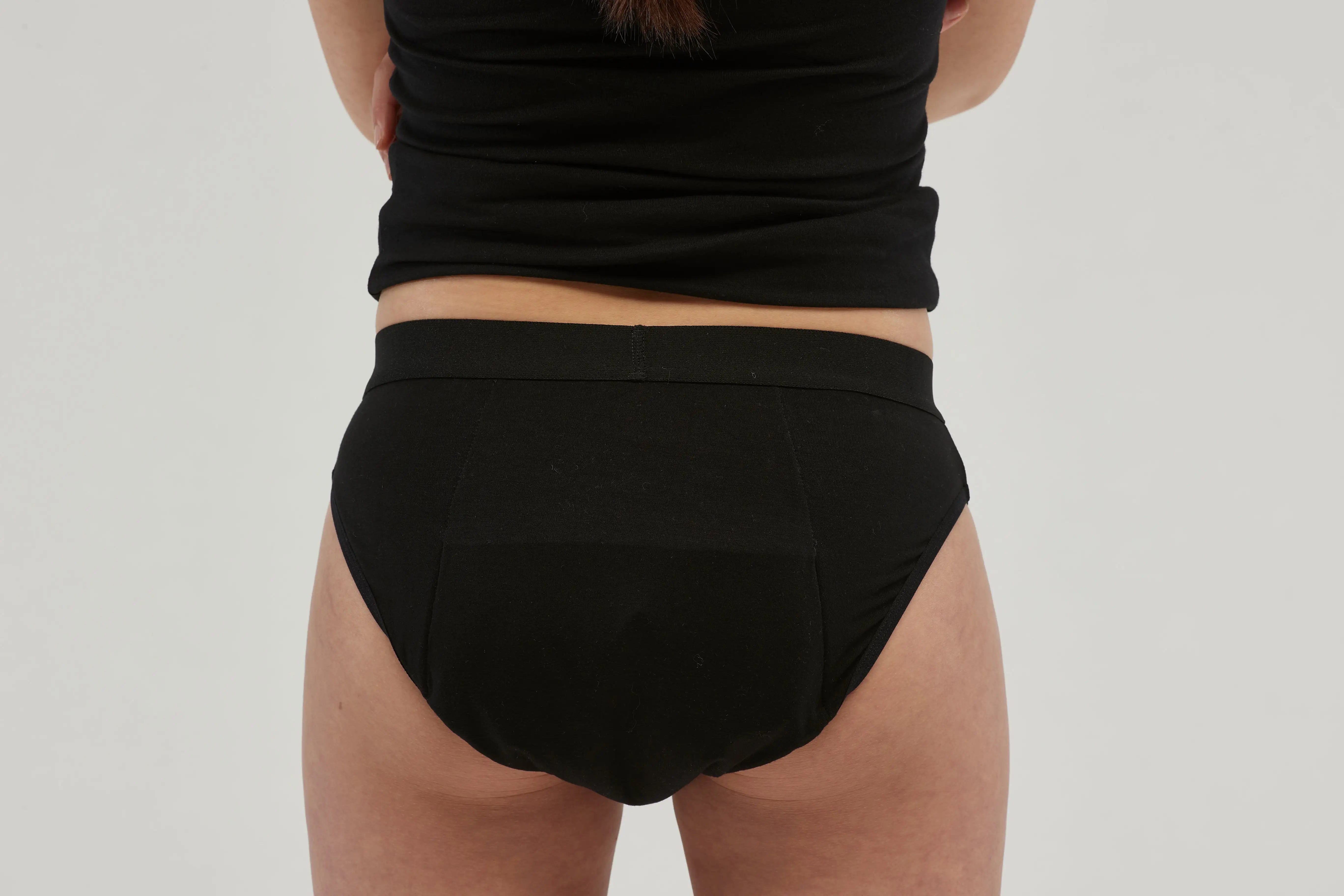 Rear view of teen girls' black incontinence underwear featuring a discreet, absorbent core and leak-proof protection. Made from breathable, moisture-wicking fabric, these machine-washable, reusable briefs provide all-day comfort and security. Designed with a seamless look and a soft elastic waistband, offering a stylish and practical solution for managing incontinence confidently.