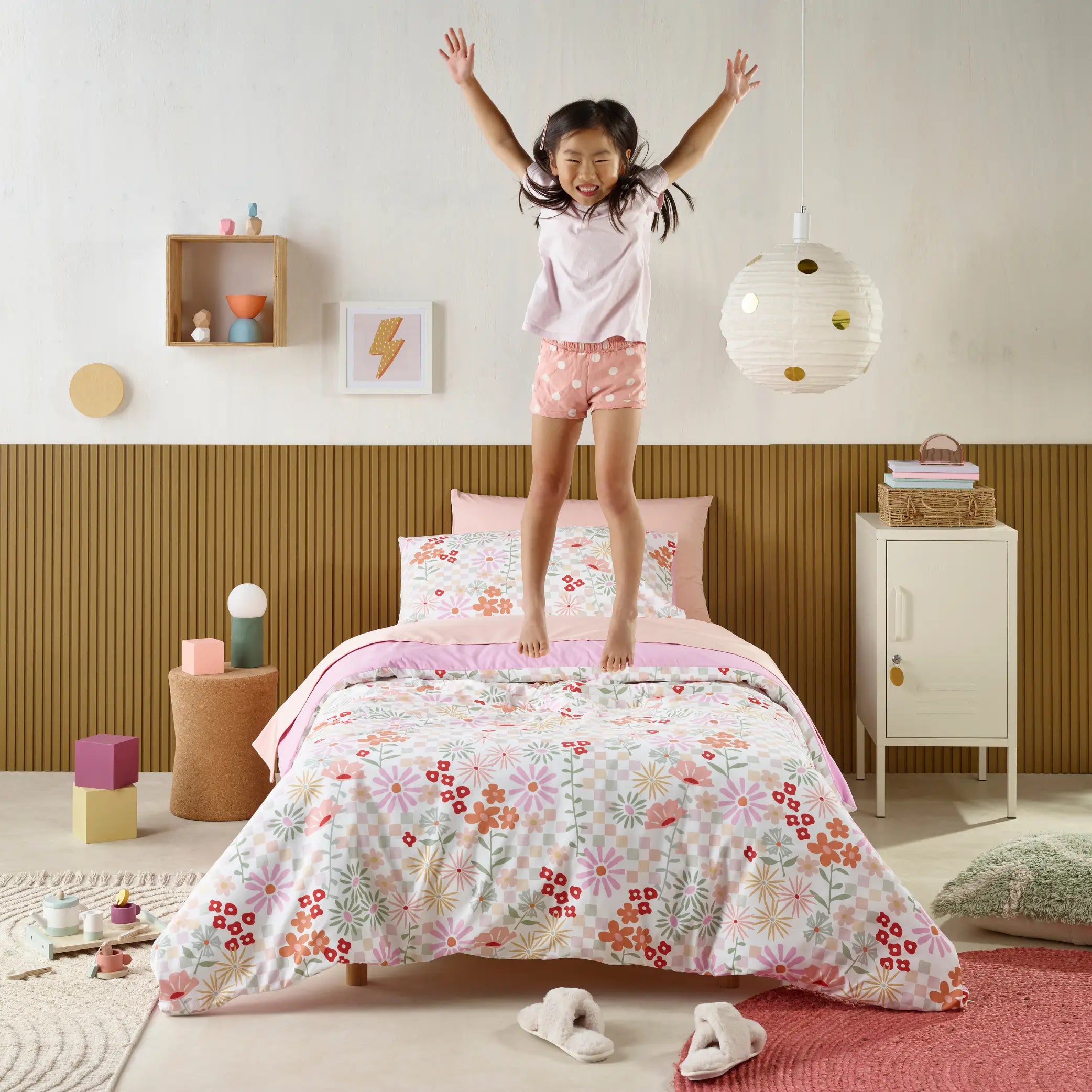 Kids' waterproof quilt cover with a vibrant floral 'Blooms' design featuring colourful flowers and geometric patterns on a soft pastel pink background. Made from breathable, moisture-resistant fabric, this durable bedding set provides incontinence protection while ensuring a cosy and comfortable night's sleep. Ideal for children who need extra bed protection, this machine-washable and hypoallergenic quilt cover blends practicality with a fun and stylish look.