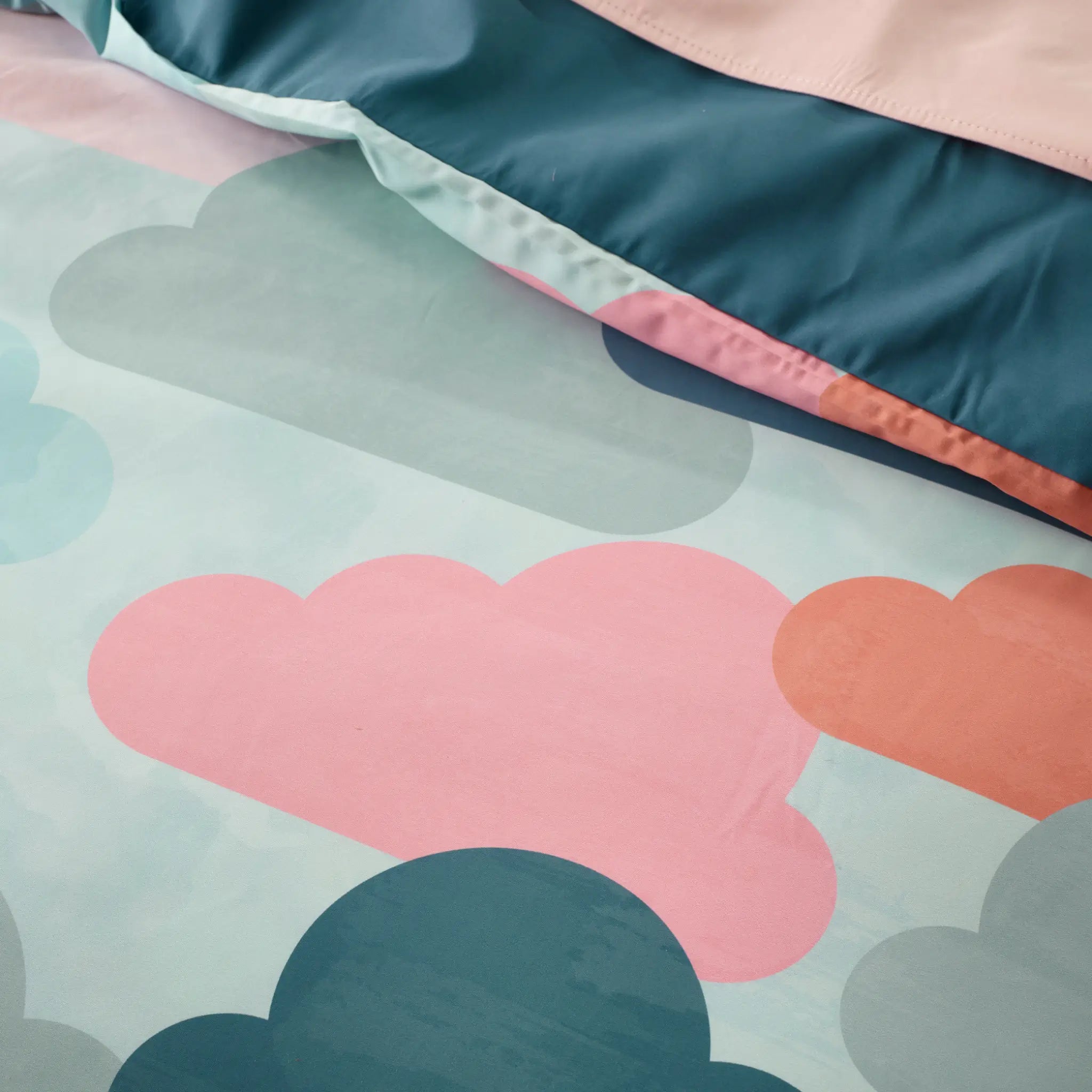 Vibrant water-resistant quilt cover set featuring a playful cloud pattern in pastel pink, teal, and peach hues. 