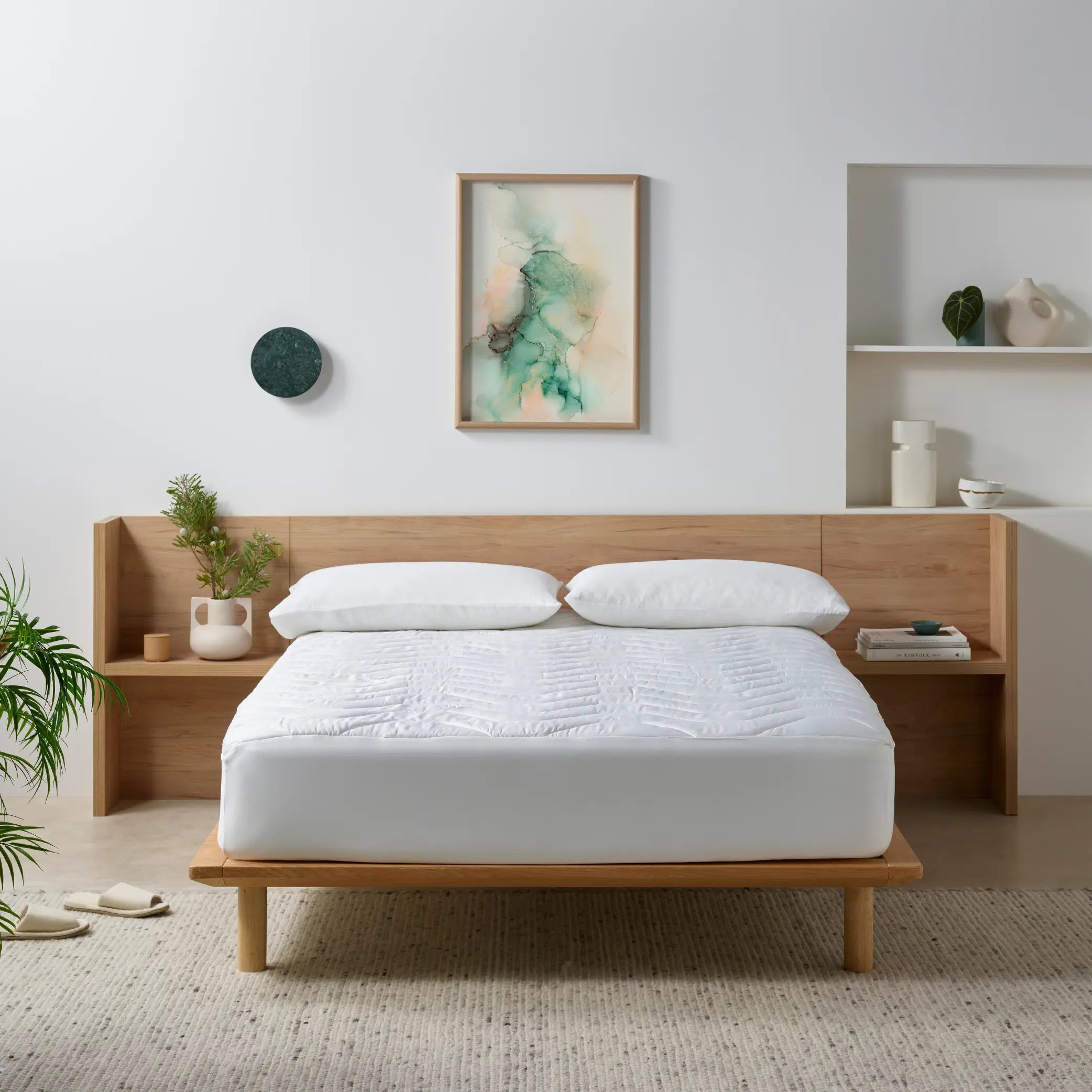 Minimalist bedroom featuring a waterproof bamboo mattress protector on a wooden bed frame. This hypoallergenic, breathable, and soft mattress cover offers protection against spills, allergens, and dust mites while enhancing sleep comfort and longevity.